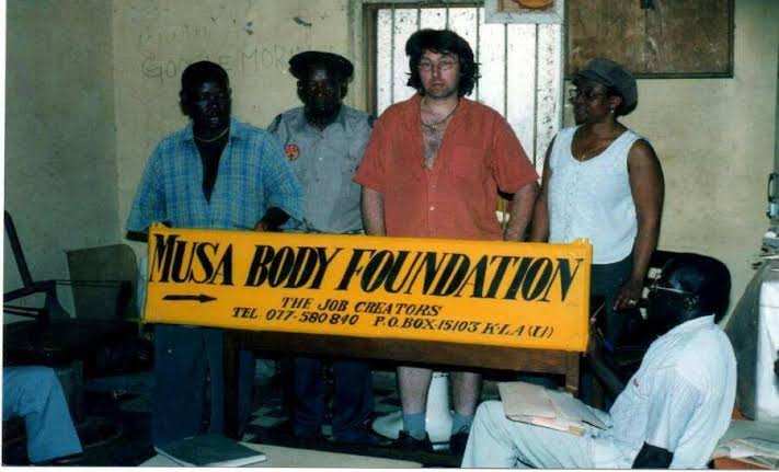 Historical group photograph with a Musa Body Foundation sign